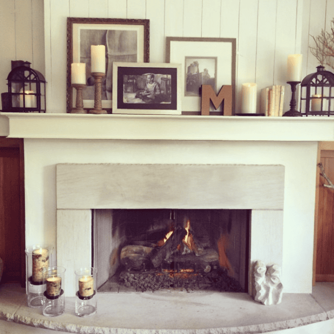 Decorate a fireplace with flameless candles, framed pictures, lanterns & candle holders