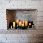 Decorate a fireplace with flameless candles, faux greenery