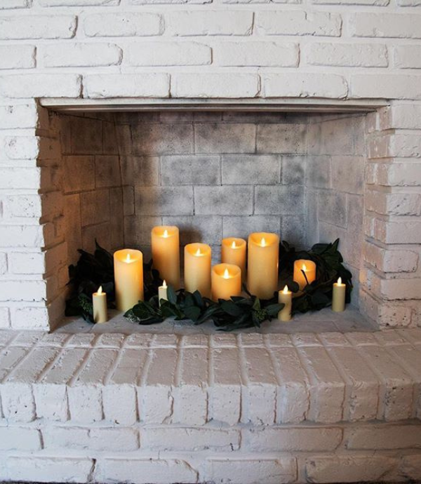 Decorate a fireplace with flameless candles, faux greenery
