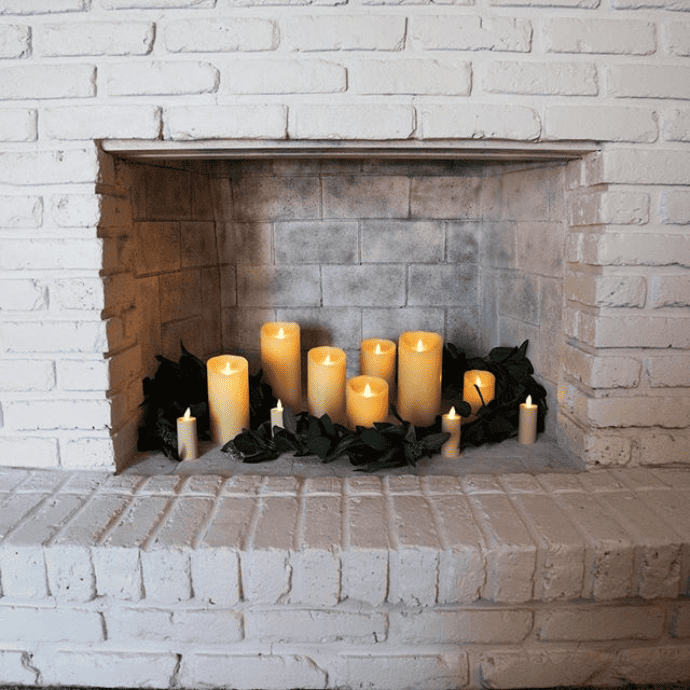 Decorate a fireplace with flameless candles, faux greenery
