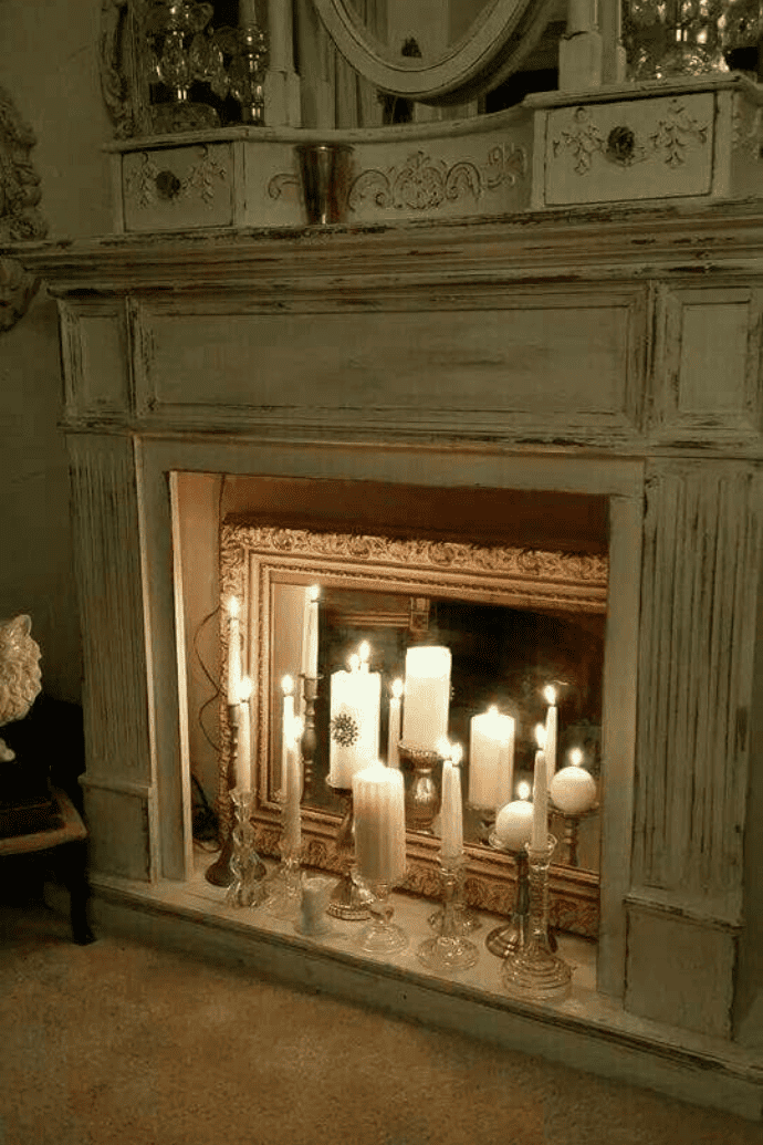 Decorate a fireplace with flameless candles, mercury glass candle holders, taper candles & a mirror