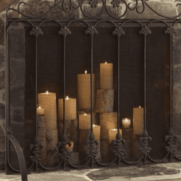 Decorate a fireplace with flameless candles, wood candle holders & a fireplace screen