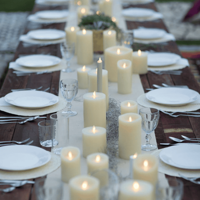 Flameless candle wedding centerpiece with a table runner, pillar candles & taper candles