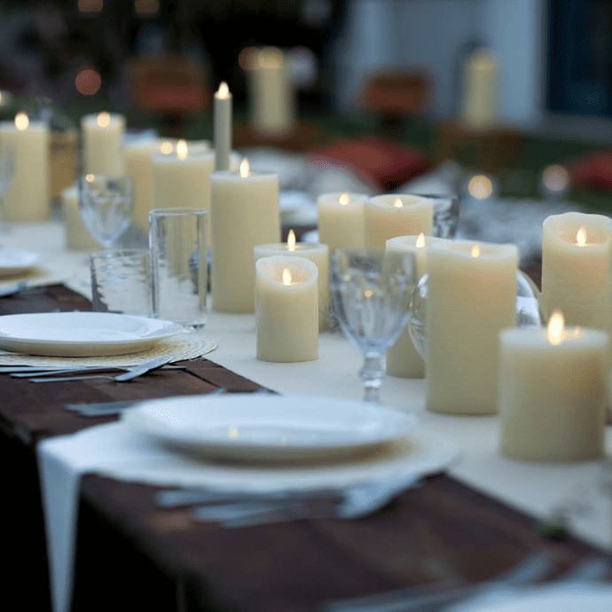 Flameless candle wedding centerpiece with a table runner, pillar candles & taper candles