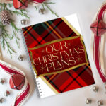 Ultimate Christmas planner printable on a table with jingle bells, ribbons