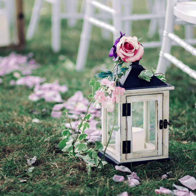 Flameless candles for wedding aisles with lanterns, flowers, rose petals