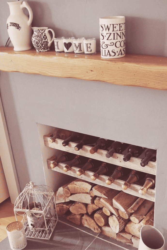 unusable fireplace with logs, wine bottles