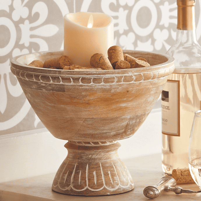 flameless candle in decorative bowl with bottle of wine