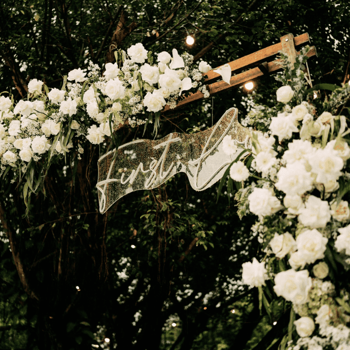 first love wedding sign on acrylic backing with flowers, arch