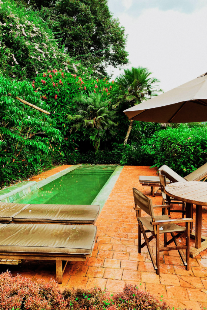 furniture on a small pool deck with landscaping