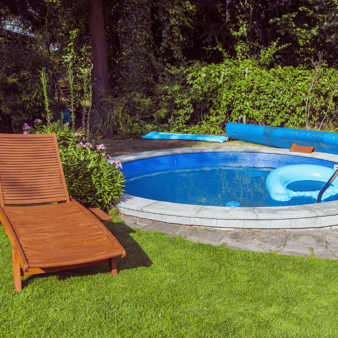 wood lounge chair by small in ground pool backyard landscaping